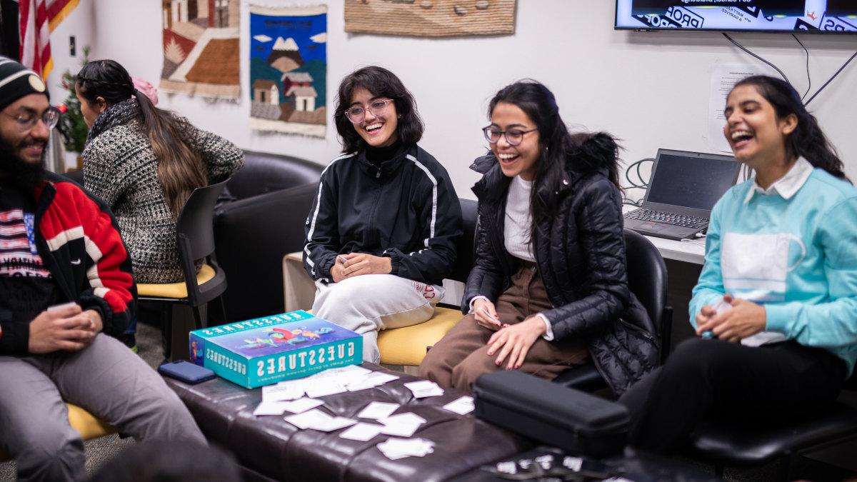 International students laughing while playing board games