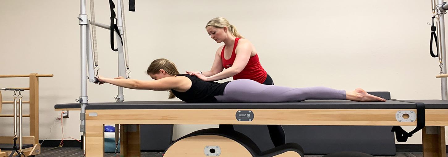 Pilates instructor assist another person